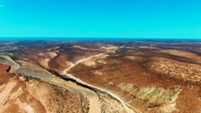 SAN JUANICO BCS MEXICO-2022: Receding Water in Desert Riverbed Alongside Dirt Road