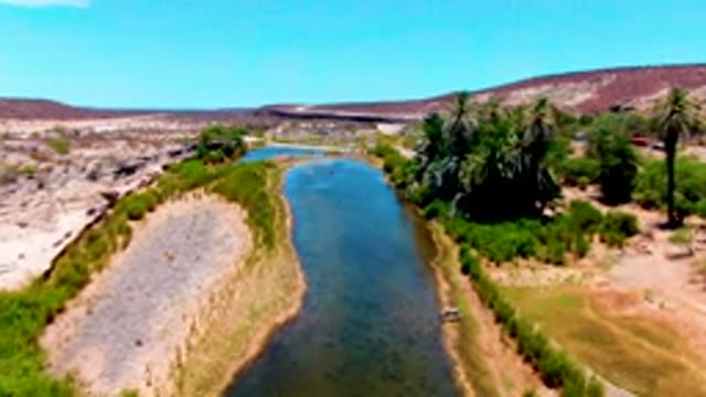 SAN JUANICO BCS MEXICO-2022: Vehicle Moving Along Riverbank in Dry Terrain