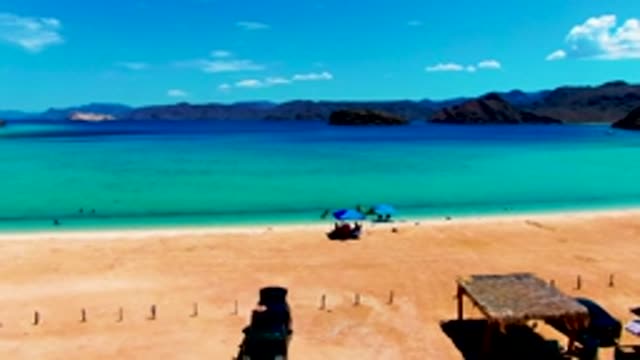 PLAYA SANTISPAC BCS MEXICO-2022: Car Driving on Sandy Beach with Turquoise Water