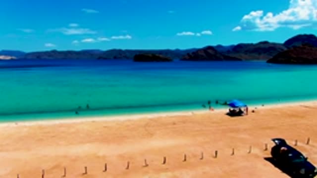PLAYA SANTISPAC BCS MEXICO-2022: Beachgoers Swimming and a Car Departing the Shore