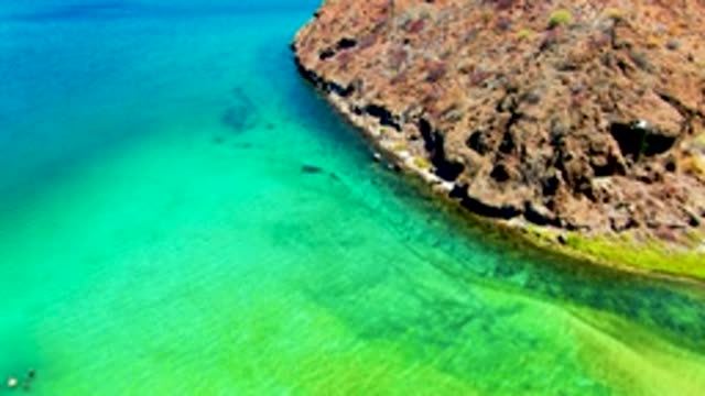 PLAYA SANTISPAC BCS MEXICO-2022: Rocky Coast with Swimmers in Turquoise Water