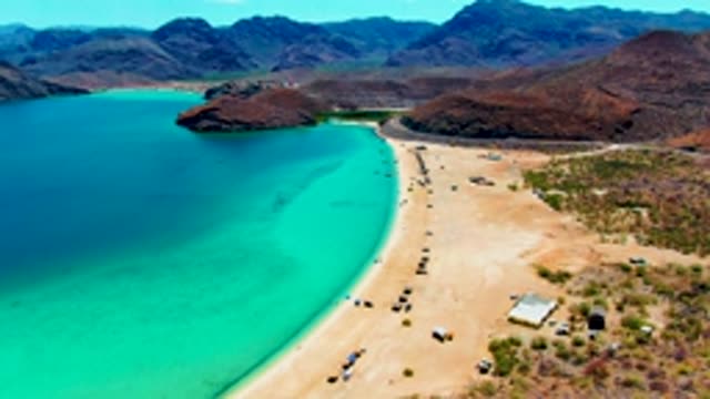 PLAYA SANTISPAC BCS MEXICO-2022: Sandy Beach with Turquoise Water and Moving Vehicles