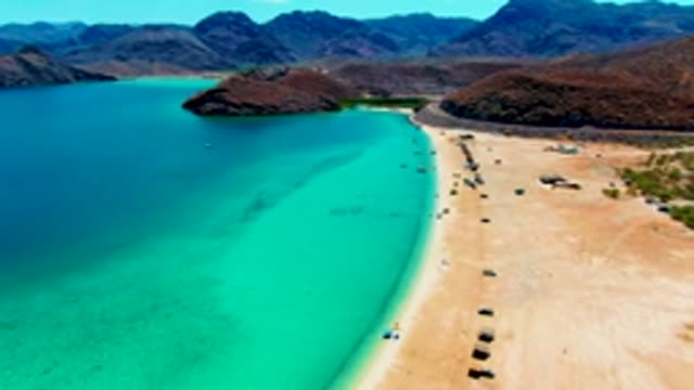 PLAYA SANTISPAC BCS MEXICO-2022: Vehicles Traverse a Sandy Beach with Turquoise Waters