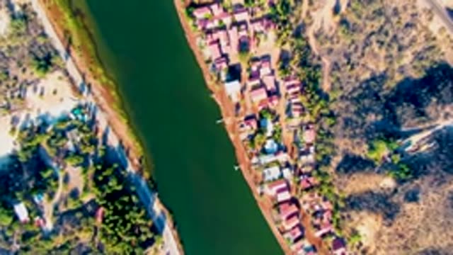 MULEGE BCS MEXICO-2022: Riverside Community with Red-roofed Houses and Narrow River