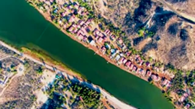 MULEGE BCS MEXICO-2022: Riverbank Houses with Vehicle Moving on Adjacent Road