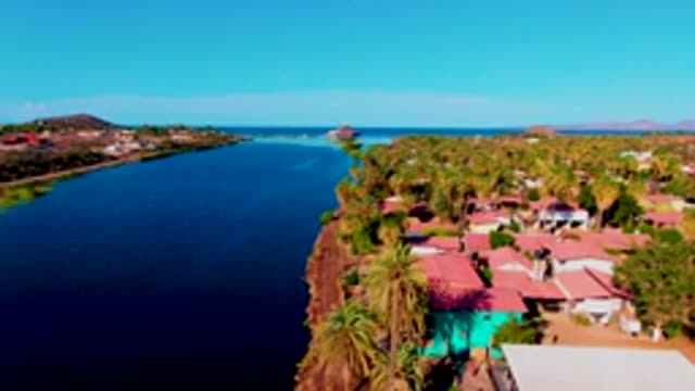 MULEGE BCS MEXICO-2022: Coastal Waterway with Red-Roofed Buildings and Palm Trees