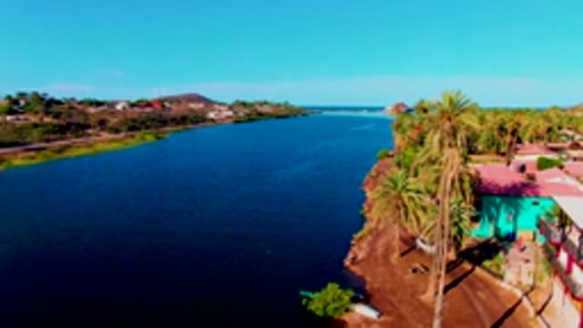 MULEGE BCS MEXICO-2022: Riverbank with Moving Vehicle and Palm Trees