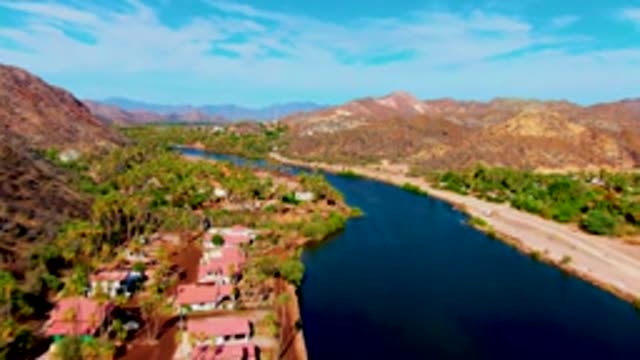 MULEGE BCS MEXICO-2022: Vehicles Traveling Along Waterway Near Mountainous Landscape