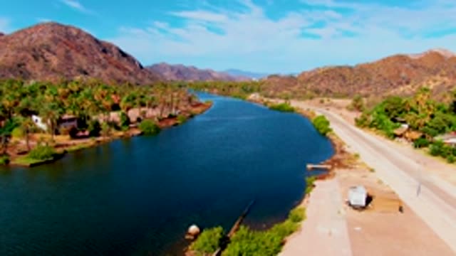 MULEGE BCS MEXICO-2022: Vehicle Moving Along River Road with Mountain Backdrop