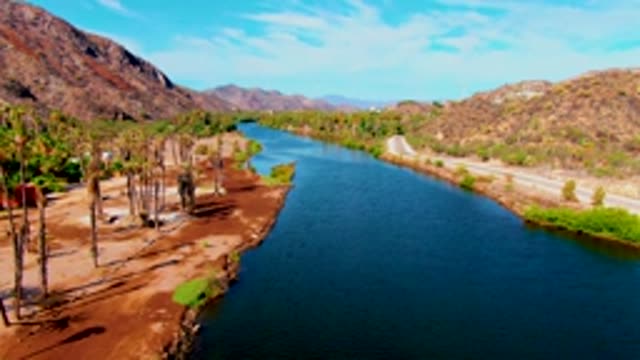 MULEGE BCS MEXICO-2022: Desert River with Palm Trees and Mountain Backdrop