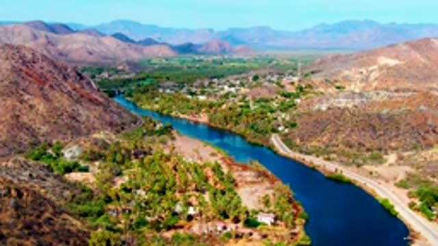 MULEGE BCS MEXICO-2022: Winding River and Road with Moving Vehicles in Hilly Terrain