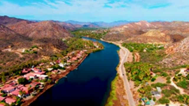 MULEGE BCS MEXICO-2022: River, Road, and Vehicle Moving Through Mountain Valley