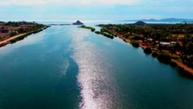 MULEGE BCS MEXICO-2022: Canal with Shimmering Water and Tree-Lined Banks