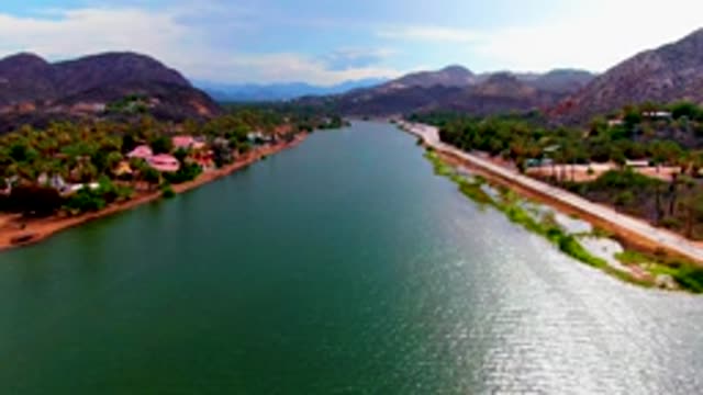 MULEGE BCS MEXICO-2022: River Flowing Between Road and Residential Area with Mountains