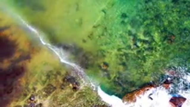 Waves Crashing on Rocky Shore From Above