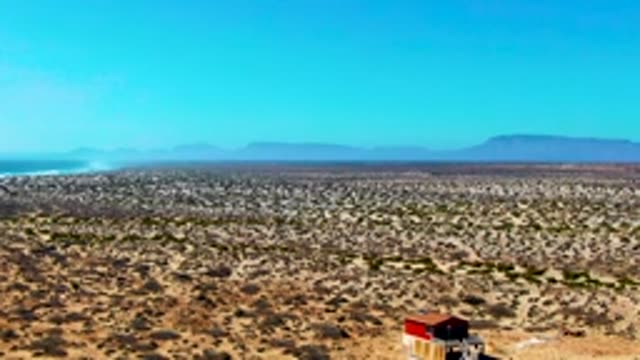 Arid Desert Plain with Isolated Structure and Distant Mountains