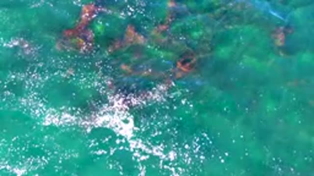 Clear Turquoise Water with Submerged Rocks and Gentle Ripples