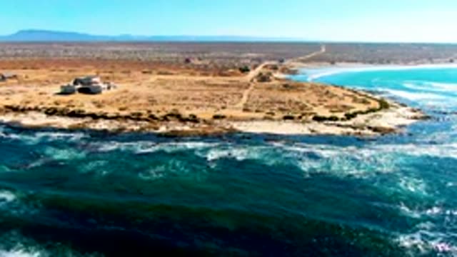 Coastal Headland with Small Building and Ocean Waves