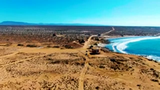 Arid Coastal Road and Distant Settlement