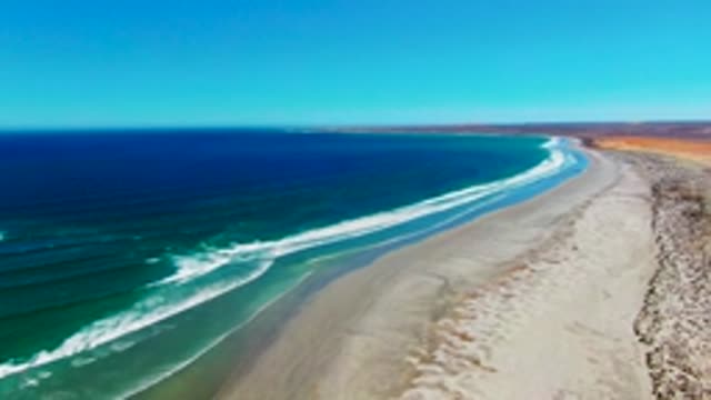 Waves Rolling Onto Sandy Beach Coastline