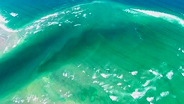 Curving Ocean Wave with Turquoise Water and White Foam