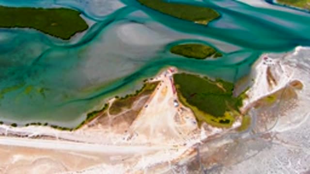 Coastal Sand Dunes and Turquoise Waters with Beach Activity