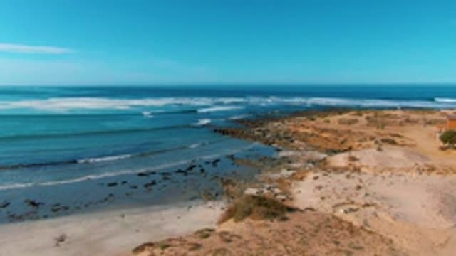 LA BOCANA BCS MEXICO-2022: Waves Rolling Onto Sandy Beach with Rocky Outcrops
