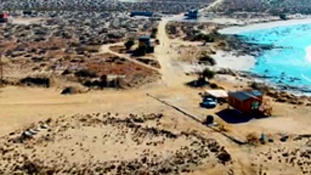LA BOCANA BCS MEXICO-2022: White Car Traveling on Desert Dirt Road by Water