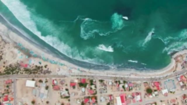 PUENTA ABREOJOS BCS MEXICO-2022: Waves Rolling Onto Sandy Beach with Colorful Umbrellas