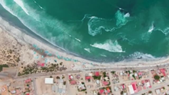 PUENTA ABREOJOS BCS MEXICO-2022: Waves Rolling Onto Sandy Beach with Coastal Buildings