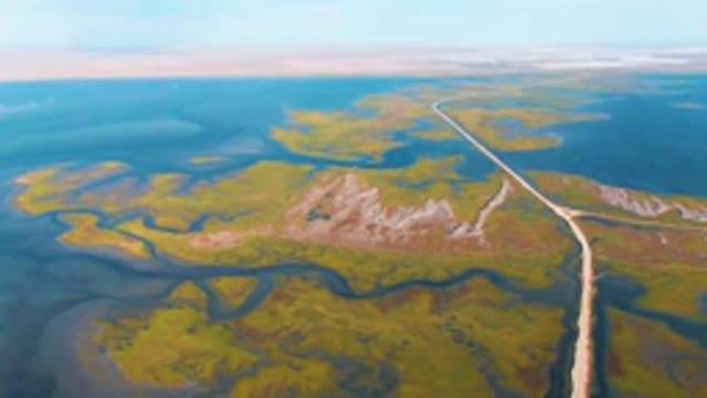 GUERRERO NEGRO BCS MEXICO-2022: Vehicle Moving Along Remote Road in Wetland Landscape