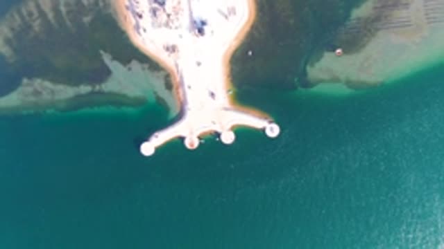 GUERRERO NEGRO BCS MEXICO-2022: Sandy Shore with Dock Extending Into Clear Water