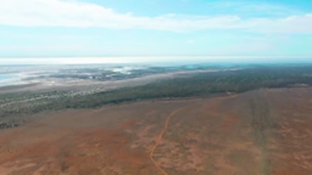 GUERRERO NEGRO BCS MEXICO-2022: Red Earth Plain with Road and Distant Water
