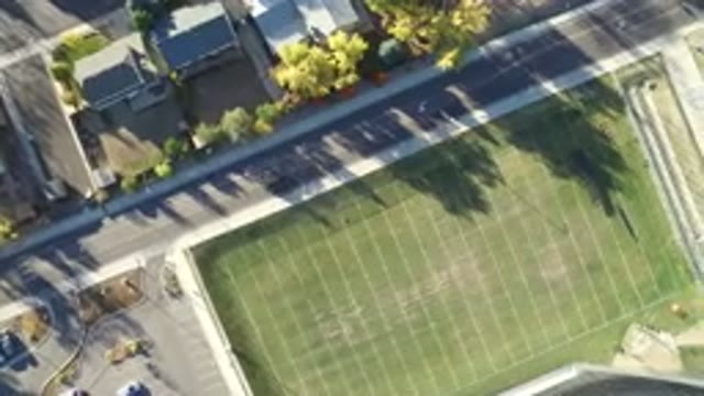 HIDDEN LAKE COLORADO-2016: Aerial View In Motion Of Moving Car Beside Football Field