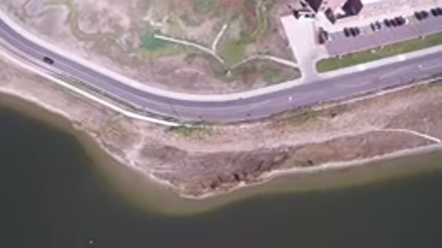 HIDDEN LAKE COLORADO-2016: Aerial View Of A Windy Road And Cars Driving Through Grass