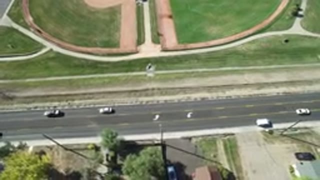 HIDDEN LAKE COLORADO-2016: An Aerial View Of A Road With Some Cars On It And Green Fields