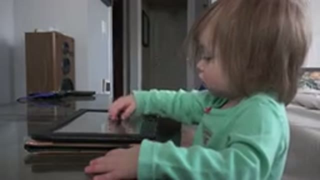 WESTMINSTER COLORADO-2016: Baby Girl Playing With A Tablet On The Table In The Bedroom