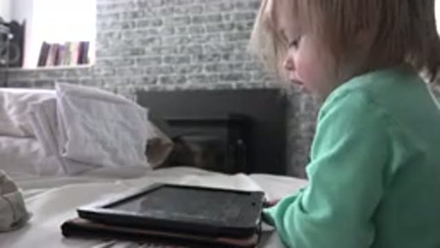 WESTMINSTER COLORADO-2016: Young Child In Green Shirt Watching And Touching An iPad