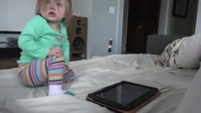 WESTMINSTER COLORADO-2016: Child In Green T-Shirt On Bed Next To Tablet
