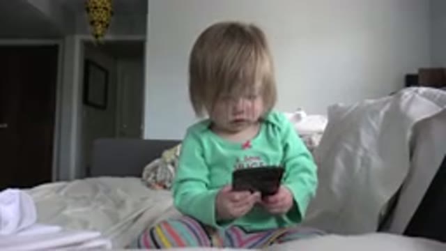 WESTMINSTER COLORADO-2016: Blond Baby Wearing Colorful Clothes Holding Cellphone