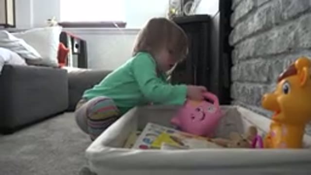 WESTMINSTER COLORADO-2016: Small Toddler Girl Looks At The Toys In Her Toy Box