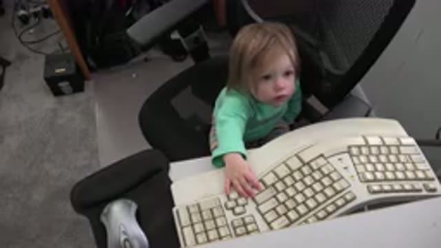 WESTMINSTER COLORADO-2016: Curious Baby Girl Sitting On A Computer Chair And Touching Keyboard