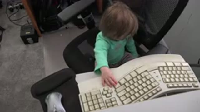 WESTMINSTER COLORADO-2016: Child Sitting At A Desk Playing With An Ergonomic Keyboard