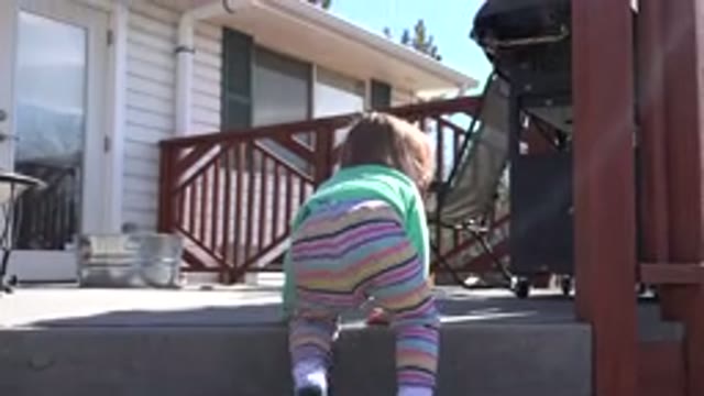 WESTMINSTER COLORADO-2016: Child Girl In A Backyard Of A House Trying To Climb A Ladder
