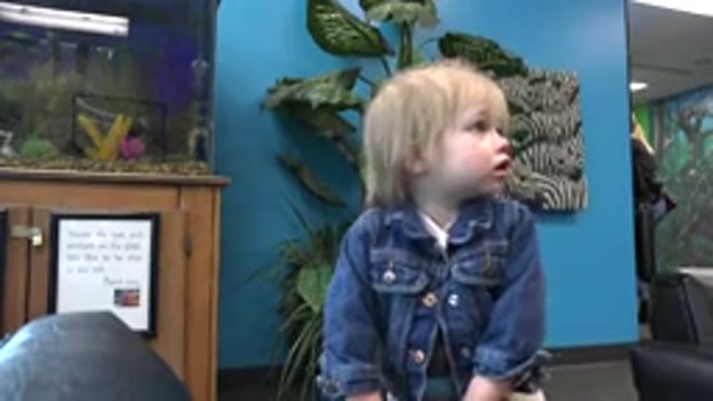 DENVER COLORADO-2016: A Child with Blond Hair and Blue Eyes in a Denim Jacket Looks Around