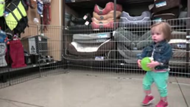 DENVER COLORADO-2016: Baby Girl Standing in Storage Holding a Ball