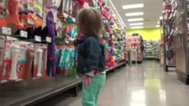 DENVER COLORADO-2016: A Baby Girl Curiously Explores a Store Aisle