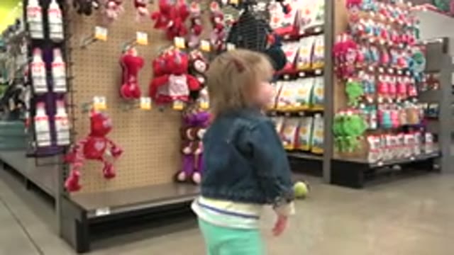DENVER COLORADO-2016: Baby Walking In A Supermarket Ally In Toy Section And Picking Up A Ball