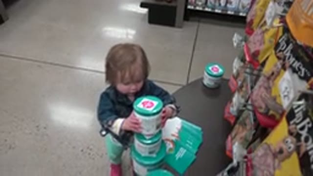 DENVER COLORADO-2016: Young Girl Stacks Green and White Containers on Top of Each Other