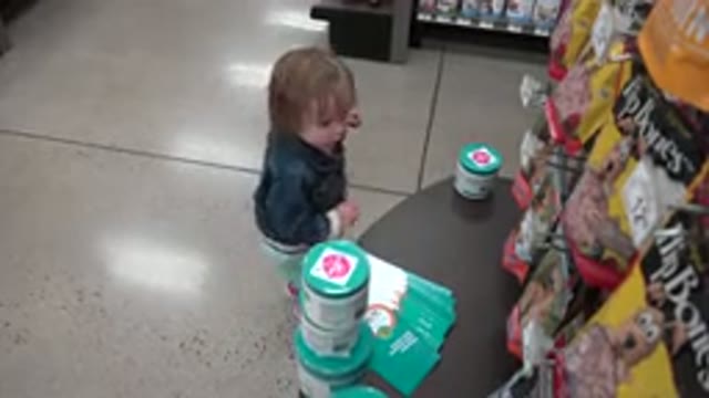 DENVER COLORADO-2016: Young Child In A Grocery Store Picking Up An Item And